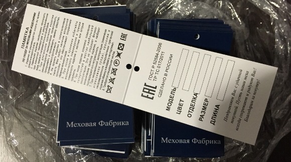 Три бирки Черного цвета. Одна лежит поверх двух других и показывается как выглядит внутренняя сторона с напечатанной информацией